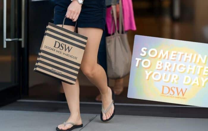 woman walking out of a store with a dsw shopping bag