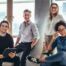 A group of 4 happy coworkers in a modern work environment.