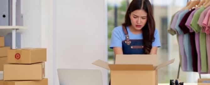 Concerned online store owner looking into a returned package with frustration, surrounded by shipping boxes and merchandise.